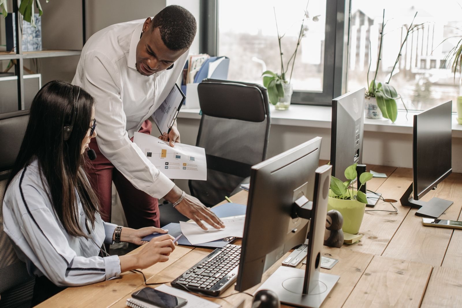 An IT technician helping a colleague at her desk