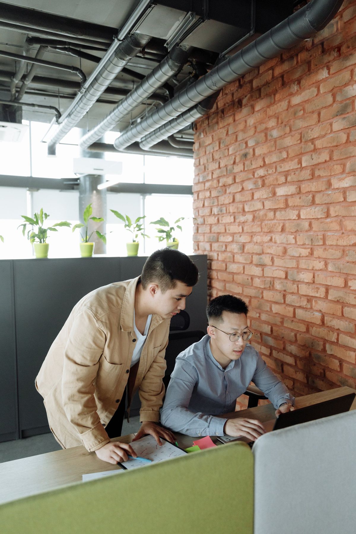 Two colleagues reviewing a laptop together