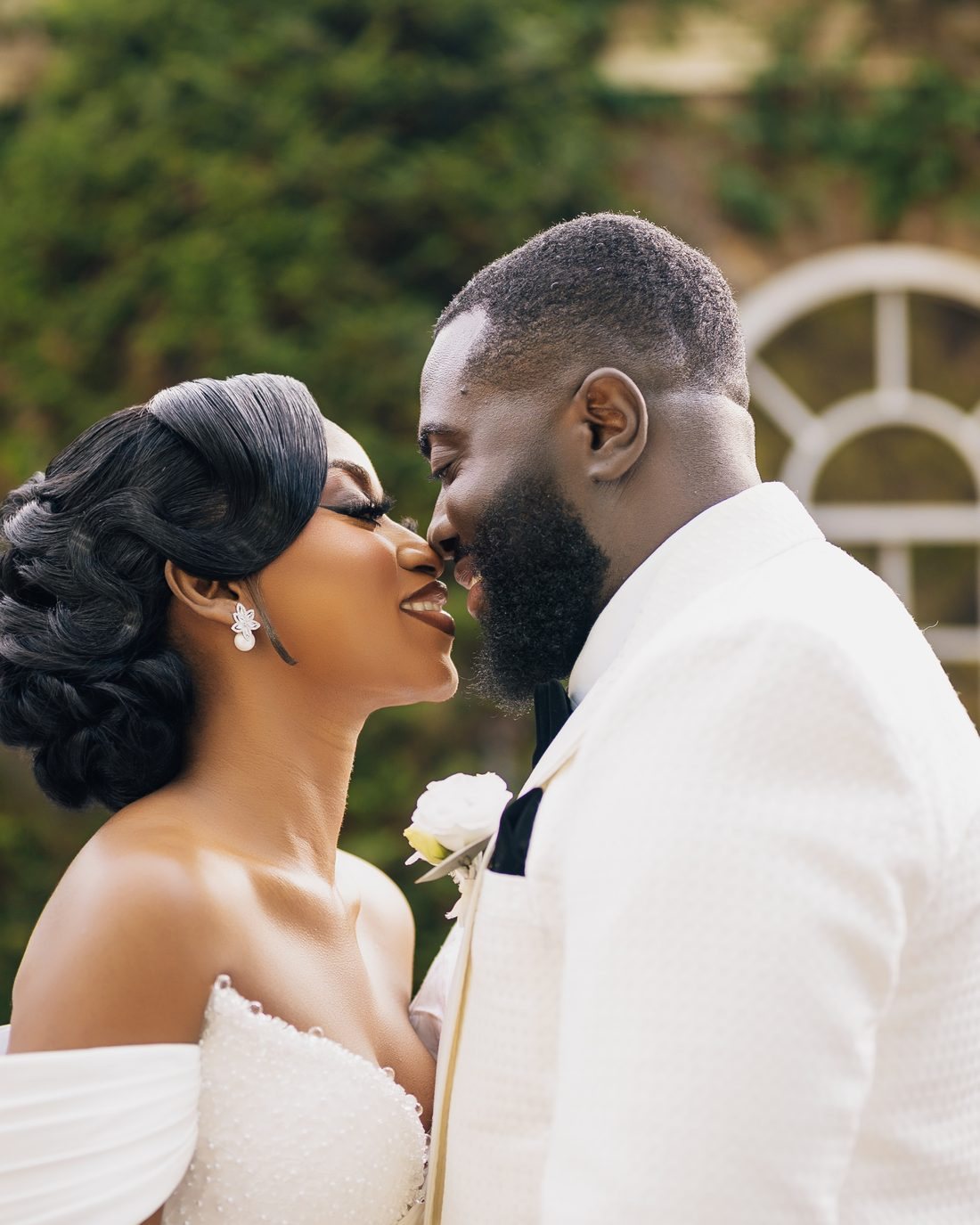 A bride and groom kissing beside the car
