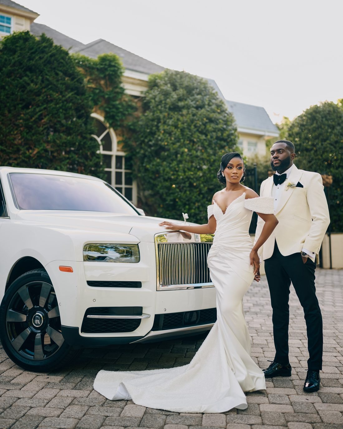 A couple arriving at the venue beside a white car