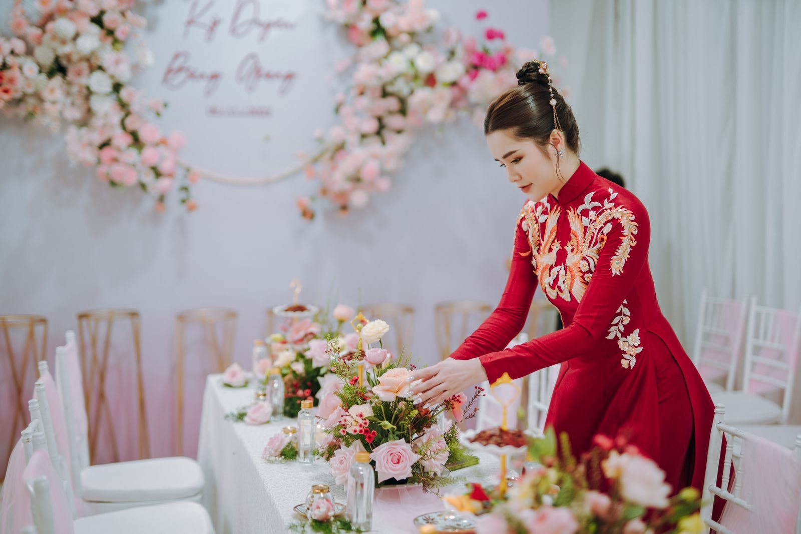 A planner arranging a floral centrepiece at a reception table