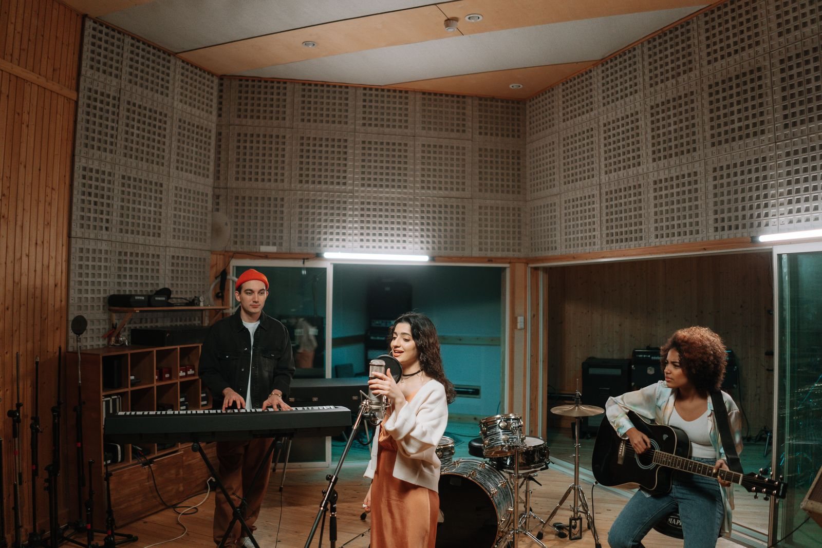 A band rehearsing with keys, vocals and guitar in the live room
