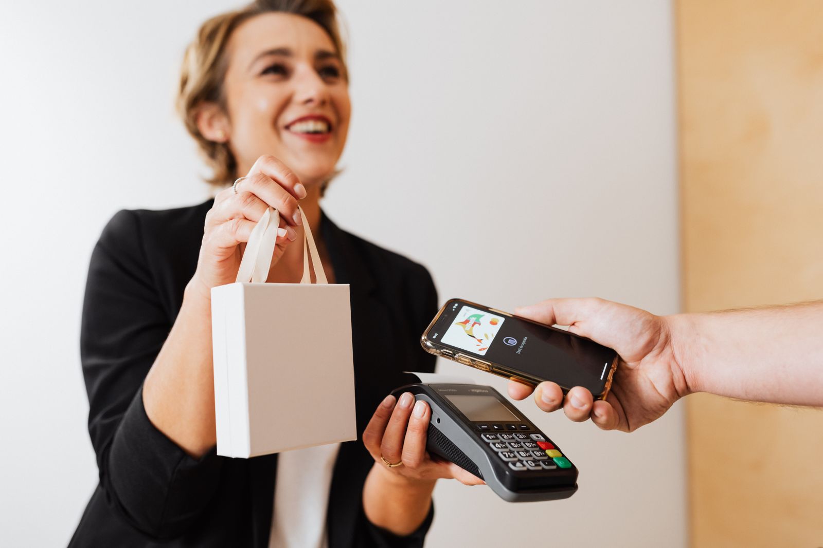 A shop owner taking a contactless payment from a customer