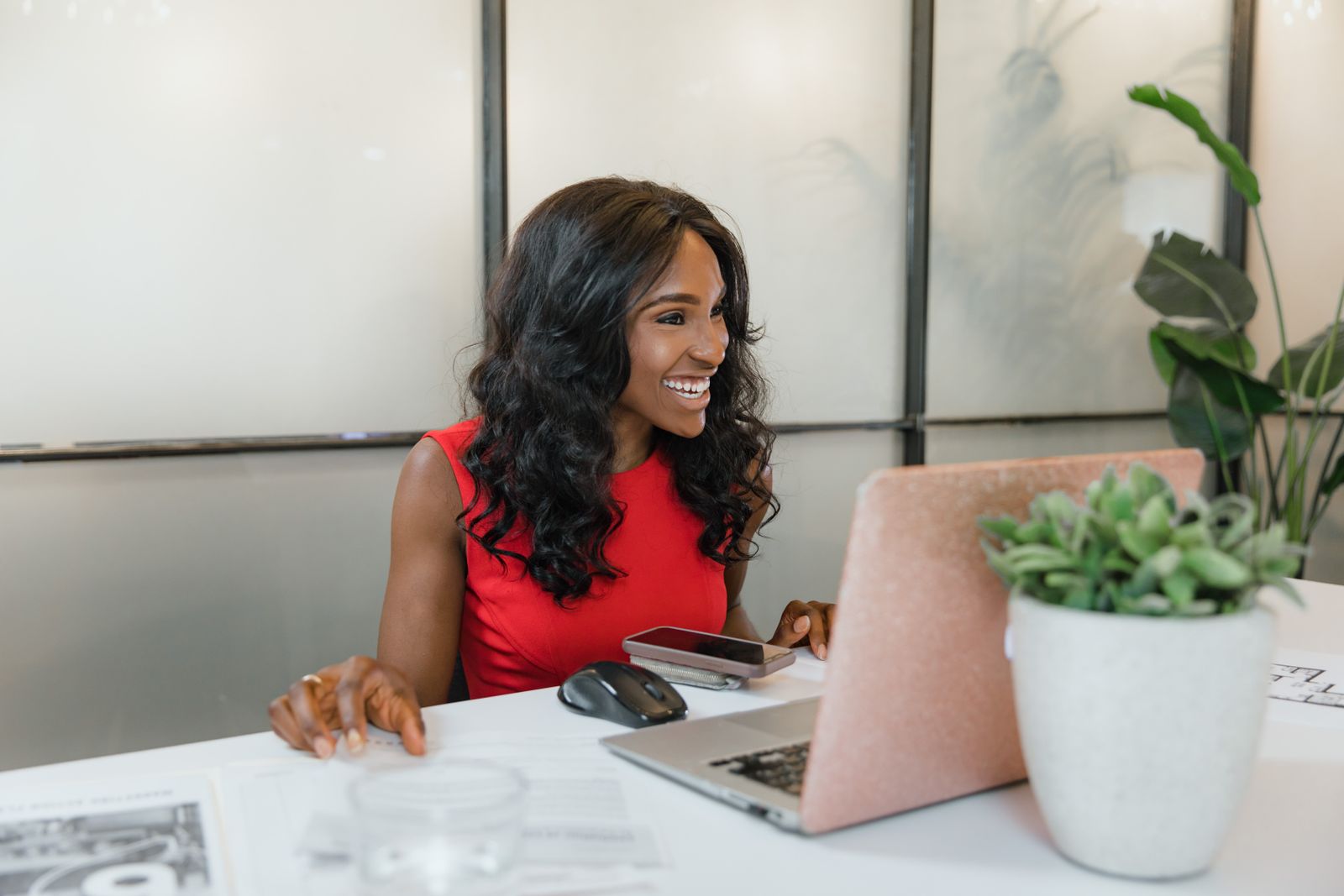 A business owner smiling at her laptop at the front desk